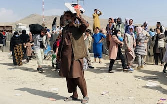 epa09419998 Afghans gather outside the Hamid Karzai International Airport to flee the country, in Kabul, Afghanistan, 19 August 2021. Thousands of desperate Afghans, including the elderly as well as women and children, have camped outside the Kabul airport for days in the hope of getting evacuated from the country after it was taken over by the Taliban.  EPA/STRINGER