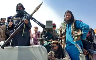 TOPSHOT - Taliban fighters sit over a vehicle on a street in Laghman province on August 15, 2021. (Photo by - / AFP) (Photo by -/AFP via Getty Images)