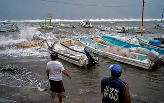 Fishermen prepare to remove boats from the dock as strong waves reach the coast due to Hurricane Grace, which has reached category 2, in Boca del Rio, Veracruz, Mexico, on August 20, 2021. - Grace regained hurricane strength Friday as it barreled towards Mexico for a second time, triggering warnings of flooding and mudslides in mountains on the eastern mainland. (Photo by VICTORIA RAZO / AFP) (Photo by VICTORIA RAZO/AFP via Getty Images)