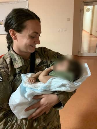 KABUL, AFGHANISTAN: Sergeant Breanna Jessop, XVIII Airborne Corps' 82nd Airborne, cares for an Afghan child at the Hamid Karzai International Airport. Our Soldiers continue to support the Non-Combatant Evacuation mission. We are the #ImmediateResponseForce.