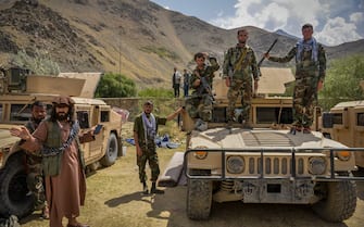 Afghan armed men supporting the Afghan security forces against the Taliban stand with their weapons and Humvee vehicles at Parakh area in Bazarak, Panjshir province on August 19, 2021. (Photo by Ahmad SAHEL ARMAN / AFP) (Photo by AHMAD SAHEL ARMAN/AFP via Getty Images)