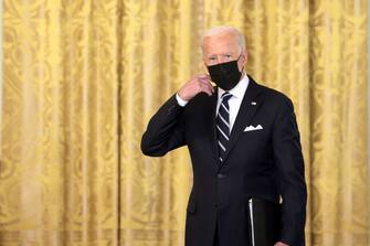 WASHINGTON, DC - AUGUST 18: U.S. President Joe Biden removes his face mask as he arrives to deliver remarks on the COVID-19 response and the vaccination program in the East Room of the White House on August 18, 2021 in Washington, DC. During his remarks, President Biden announced that he is ordering the United States Department of Health and Human Services to require nursing homes to have vaccinated staff in order for them to receive Medicare and Medicaid funding. The President also announced that Americans would be able to receive a third booster shot against Covid-19. (Photo by Anna Moneymaker/Getty Images)