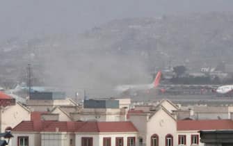 epa09430529 Smoke billows from the airport area after a blast outside the Hamid Karzai International Airport, in Kabul, Afghanistan, 26 August 2021. At least 13 people including children were killed in a blast outside the airport on 26 August. The blast occurred outside the Abbey Gate and follows recent security warnings of attacks ahead of the 31 August deadline for US troops withdrawal.  EPA/AKHTER GULFAM