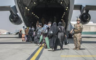 Cittadini afghani mentre salgono su un aereo militare per lasciare Kabul