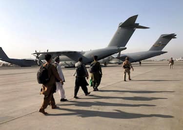 epa09425835 People line up to board a military aircraft as they are evacuated at Hamid Karzai International Airport, in Kabul, Afghanistan, 23 August 2021. An Afghan policeman was killed on 23 August in a gun battle between security forces and unknown attackers at the North Gate of the Kabul airport, the German military said, amid ongoing chaos at the airport as thousands try to flee Taliban rule.  EPA/STRINGER BEST QUALITY AVAILABLE