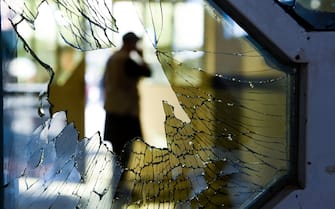 TOPSHOT - A man is seen through a broken window of a wedding hall after a deadly bomb blast in Kabul on August 18, 2019. - More than 60 people were killed and scores wounded in an explosion targeting a wedding in the Afghan capital, authorities said on August 18, the deadliest attack in Kabul in recent months. (Photo by Wakil KOHSAR / AFP)        (Photo credit should read WAKIL KOHSAR/AFP via Getty Images)