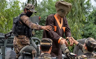 Forces with Afghanistan's National Directorate of Security (NDS) escort an alleged militant as Taliban and Islamic State (IS) fighters are presented to the media in Jalalabad on May 23, 2019. - Afghan security forces have detained seven alleged Taliban and four ISIS militants and seized a suicide vest and ammunition during an operation in Nangarhar province, an official said. (Photo by NOORULLAH SHIRZADA / AFP)        (Photo credit should read NOORULLAH SHIRZADA/AFP via Getty Images)