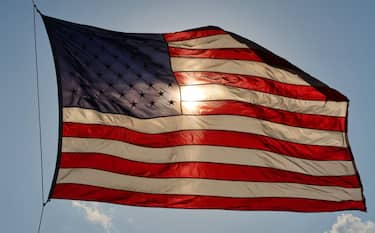 HOBOKEN, NJ - MAY 15: The sun sets behind an American Flag on May 14, 2020 in Hoboken, New Jersey. (Photo by Gary Hershorn/Getty Images)