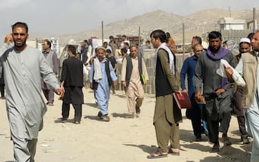 epaselect epa09419997 Afghans gather outside the Hamid Karzai International Airport to flee the country, in Kabul, Afghanistan, 19 August 2021. Thousands of desperate Afghans, including the elderly as well as women and children, have camped outside the Kabul airport for days in the hope of getting evacuated from the country after it was taken over by the Taliban.  EPA/STRINGER
