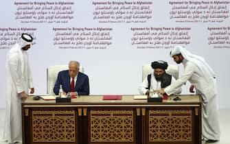 (L to R) US Special Representative for Afghanistan Reconciliation Zalmay Khalilzad and Taliban co-founder Mullah Abdul Ghani Baradar sign a peace agreement during a ceremony in the Qatari capital Doha on February 29, 2020. - The United States signed a landmark deal with the Taliban, laying out a timetable for a full troop withdrawal from Afghanistan within 14 months as it seeks an exit from its longest-ever war. Pompeo called on the Taliban to honour its commitments to sever ties with jihadist groups as Washington signed a landmark deal with the Afghan insurgents. (Photo by KARIM JAAFAR / AFP) (Photo by KARIM JAAFAR/AFP via Getty Images)