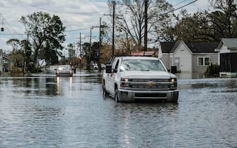 epa09437423 Trucks drive though a flooded neighborhood from Hurricane Ida in Narco, Louisiana, USA, 30 August 2021. Hurricane Ida made landfall as a Category 4 storm bringing damaging winds and rain to southern Louisiana, knocking out power to more than one million people and flooding neighborhoods. At least one person was reported killed by the passing of the hurricane.  EPA/DAN ANDERSON