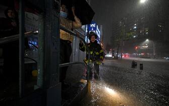 A member of the FDNY directs people stranded at a subway entrance during flash flooding caused by Hurricane Ida in the New York City borough of Queens, NY, September 1, 2021.More than three inches of rain fell per hour, causing New York City subway system to be temporarily suspended. (Photo by Anthony Behar/Sipa USA)
