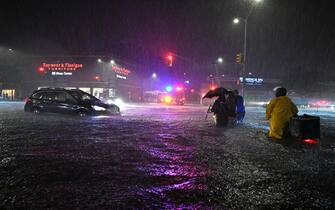Members of the FDNY help people across Queens Boulevard through flash flood waters after remnants of Hurricane Ida brought three inches of rain per hour across the city, in the New York City borough of Queens, NY, September 1, 2021. (Photo by Anthony Behar/Sipa USA)
