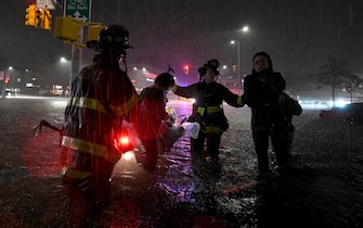 Members of the FDNY rescue a woman from her car stalled due to flash flooding after remnants of Hurricane Ida brought three inches of rain per hour across the city, in the New York City borough of Queens, NY, September 1, 2021. (Photo by Anthony Behar/Sipa USA)