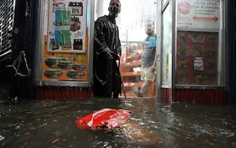 A homeless man stands in the doorway of a deli during flash flooding caused by storm Ida in the New York City borough of Queens, NY, September 1, 2021. (Photo by Anthony Behar/Sipa USA)