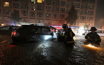 Members of the FDNY rescue a woman from her car stalled due to flash flooding after remnants of storm Ida brought three inches of rain per hour across the city, in the New York City borough of Queens, NY, September 1, 2021. (Photo by Anthony Behar/Sipa USA)