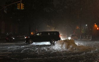 A car passes water gushing out of a manhole as remnants of Hurricane Ida causes flash flooding across the city, in the New York City borough of Queens, NY, September 1, 2021. More than three inches of rain fell per hour, causing New York City subway system to be temporarily suspended. (Photo by Anthony Behar/Sipa USA)