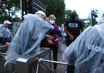 Staff check in fans as they arrive at the USTA Billie Jean King National Tennis Center in New York, on September 1, 2021. - Outside court matches have been postponed as the remnants for Hurricane Ida pass through the region. (Photo by KENA BETANCUR / AFP) (Photo by KENA BETANCUR/AFP via Getty Images)