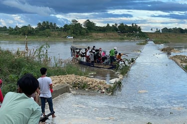 In this photo taken on September 9, 2021, residents disembark from a wooden boat serving as ferry transport in Cauayan, Isabela province in the northern Philippines after the bridge (R) was submerged by the swollen Cagayan river due to heavy rains brought by Typhoon Chanthu. (Photo by Villamor VISAYA / AFP) (Photo by VILLAMOR VISAYA/AFP via Getty Images)