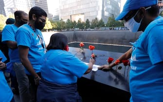 epa09461058 Family members of Jayesh Shah make a rubbing of his name at the 9/11 Memorial on the 20th anniversary of the September 11 attacks in Manhattan, New York City, U.S., September 11, 2021.  EPA/MIKE SEGAR / POOL