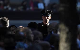 epa09461055 A New York police officer attends the ceremony at the National 9/11 Memorial commemorating the 20th anniversary of the 9/11 attacks on the World Trade Center, in New York, on September 11, 2021.  EPA/ED JONES / POOL