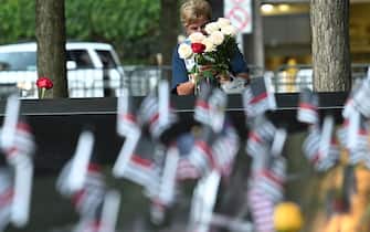 epa09461052 A woman places flowers at the South Tower on Saturday, September 11th, 2001 before ceremonies marking the 20th anniversary of the 9.11 attack at the World Trade Center in New York which killed almost 3,000 people.  EPA/David Handschuh / POOL