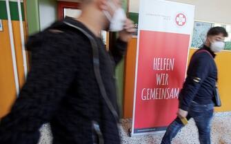 Students walk past a vaccination center against the coronavirus (Covid-19) set up at a vocational school in Vienna on September 14, 2021. - As of September 14, 2021, mobile vaccination teams in Vienna have been vaccinating against the coronavirus (Covid-19) at some schools. (Photo by ALEX HALADA / AFP) (Photo by ALEX HALADA/AFP via Getty Images)