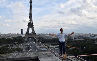 French highliner Nathan Paulin performs on a 70-metre-high slackline spanning 670 metres between the Eiffel Tower and the Theatre National de Chaillot, as part of the 38th European Heritage Days and the launch of the Cultural Olympiad in Paris, on September 18, 2021. - From the first floor of the Eiffel Tower to the Theatre National de Chaillot, the performance is the longest highline crossing in an urban environment. (Photo by Alain JOCARD / POOL / AFP) (Photo by ALAIN JOCARD/POOL/AFP via Getty Images)