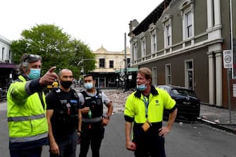 Emergency and rescue officials and police examine the area next to a damaged building in the popular shopping Chapel Street in Melbourne on September 22, 2021, after a 5.9 magnitude earthquake. (Photo by William WEST / AFP) (Photo by WILLIAM WEST/AFP via Getty Images)