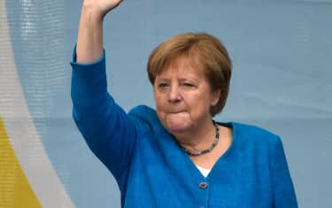 TOPSHOT - German Chancellor Angela Merkel waves as she stands on stage during a campaign rally for Christian Democratic Union CDU leader and chancellor candidate Armin Laschet (not pictured) in Aachen, western Germany, on September 25, 2021, one day ahead of the German federal elections. (Photo by Ina Fassbender / AFP)