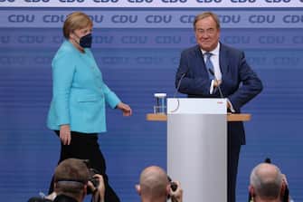 epa09490139 Armin Laschet (R), chancellor candidate of the Christian Democrats (CDU/CSU), and German chancellor Angela Merkel react to initial results at CDU headquarters during the Christian Democratic Union (CDU) election event in Berlin, Germany, 26 September 2021. About 60 million Germans were eligible to vote in the elections for a new federal parliament, the 20th Bundestag.  EPA/SEAN GALLUP / POOL