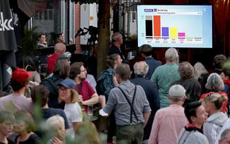 26 September 2021, Berlin: Guests of the election party of Die Linke watch the publication of a forecast of the ARD on the outcome of the Bundestag election 2021 in the Karl-Liebknecht-Haus. Photo: Jan Woitas/dpa-Zentralbild/dpa (Photo by Jan Woitas/picture alliance via Getty Images)