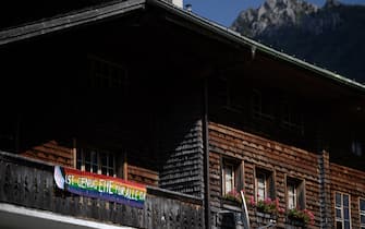 A picture taken on September 12, 2021 in the Swiss village of Jaun shows a banner hanging from a chalet reading in German: 'It's enough same-sex marriage (EHE) for all", ahead of a nationwide votation on the marriage for all. - Swiss citizens are due to vote on September 26, 2021 to determine whether the right to marry should be extended to same-sex couples or not. (Photo by Fabrice COFFRINI / AFP) (Photo by FABRICE COFFRINI/AFP via Getty Images)