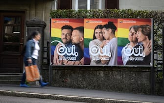 A woman walks past an electoral poster reading in French: "Yes I want it" ahead of a nationwide votation on the marriage for all, on September 22, 2021 in Lausanne. - While apartment-hunting with his partner 30 years ago, Thierry Delessert was repeatedly asked whether they were cousins, or gay. He knew the latter answer would automatically see their application thrown out. The 56-year-old historian still recalls his run-ins with "suspicious" real estate agents in Switzerland, where police in some places were still keeping registers of homosexuals. Three decades later, in a referendum on September 26, 2021, the wealthy Alpine nation looks set to allow same-sex couples to marry, and grant them the same rights as their heterosexual counterparts. (Photo by Fabrice COFFRINI / AFP) (Photo by FABRICE COFFRINI/AFP via Getty Images)