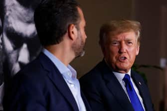 HOLLYWOOD, FLORIDA - SEPTEMBER 11: Former US President Donald Trump and Donald Trump Jr (left) talk prior to the fight between Evander Holyfield and Vitor Belfort during Evander Holyfield vs. Vitor Belfort presented by Triller at Seminole Hard Rock Hotel & Casino on September 11, 2021 in Hollywood, Florida. (Photo by Douglas P. DeFelice/Getty Images)