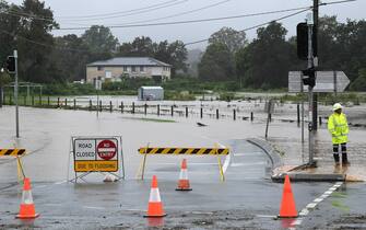 epa09090779 Flash flooding cuts a road at Mudgeeraba on the Gold Coast hinterland, Australia, 23 March 2021. The weather bureau is warning of potentially life-threatening conditions from torrential rain and storms in southern Queensland.  EPA/DAVE HUNT AUSTRALIA AND NEW ZEALAND OUT