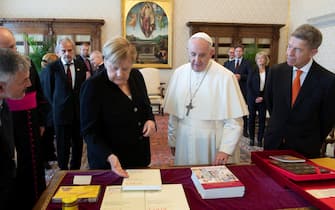 epa09510940 A handout picture provided by the Vatican broadcaster Vatican Media shows outgoing German Chancellor Angela Merkel (L) and her husband Joachim Sauer (R) during a private audience with Pope Francis (C) in Vatican City, 07 October 2021.  EPA/VATICAN MEDIA HANDOUT  HANDOUT EDITORIAL USE ONLY/NO SALES
