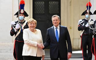 Italy's Prime Minister, Mario Draghi greets German chancellor Angela Merkel upon her arrival for their meeting at Palazzo Chigi in Rome on October 7, 2021. (Photo by Alberto PIZZOLI / AFP) (Photo by ALBERTO PIZZOLI/AFP via Getty Images)