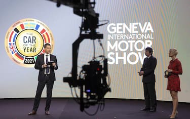 epa09045041 Sandro Mesquita, left, General Manager of Geneva International Motor Show, next to Frank Janssen, centre, Jury President of the "Car of the Year", and moderator, adresses his speech, during the virtual award ceremony of the Car of the Year 2021 due to preventive measure against propagation of the coronavirus COVID-19 pandemic, at the Palexpo in Geneva, Switzerland, 01 March 2021.  EPA/SALVATORE DI NOLFI / POOL