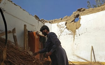 A resident removes debris of his mud house that collapsed following an earthquake in the remote mountainous district of Harnai on October 7, 2021, as around 20 people were killed and more than 200 injured when a shallow earthquake hit southwestern Pakistan in the early hours of October 7. (Photo by Banaras KHAN / AFP) (Photo by BANARAS KHAN/AFP via Getty Images)