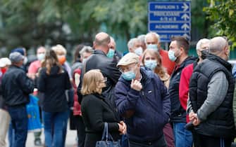 Gente con la mascherina per strada a Bucarest, in Romania