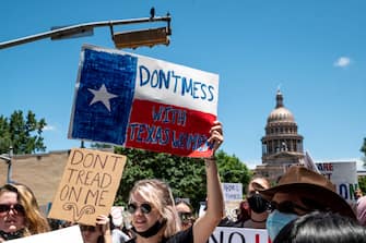 AUSTIN, TX - MAY 29: Protesters hold up signs as they march down Congress Ave at a protest outside the Texas state capitol on May 29, 2021 in Austin, Texas. Thousands of protesters came out in response to a new bill outlawing abortions after a fetal heartbeat is detected signed on Wednesday by Texas Governor Greg Abbot. (Photo by Sergio Flores/Getty Images)