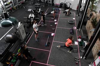 epa09517974 Gym members wear face masks as they take part in a circuit class at Fernwood Fitness Annadale gym, following 108 days of lockdown in Sydney, New South Wales, Australia, 11 October 2021. Having surpassed the 70 percent double-dose vaccination milestone early, gyms, cafes, restaurants, pools, shops, hairdressers and beauticians will reopen in New South Wales from Monday.  EPA/BIANCA DE MARCHI AUSTRALIA AND NEW ZEALAND OUT