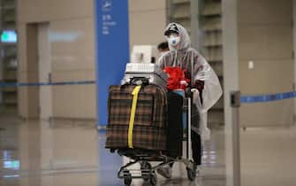 epa08326301 A passenger from Canada wearing a protective face mask walks toan 'Open Walking-Thru' centre for coronavirus COVID-19 tests at the airport in Incheon, South Korea, 27 March 2020. South Korea has reported over 9,000 ca?ses of coronavirus, the infection that causes the COVID-19 disease.  EPA/KIM CHUL-SOO