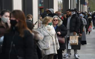 epa09130919 Shoppers queue on Oxford Street in London, Britain, 12 April 2021. From 12 April 2021, pubs and restaurants serving outside can reopen along with non-essential shops, gyms and hairdressers, as Britain's lockdown is further eased.  EPA / NEIL HALL