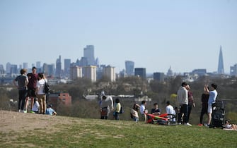 epa09106727 People enjoy the sunshine in Primrose Hill in London, Britain, 30 March 2021. From 29 March 2021 the UK government eased lockdown measures due to the coronavirus pandemic. Outdoor sport facilities including swimming pools, tennis courts and golf courses are reopening and organised outdoor sports can resume. Two households or groups of up to six people are now able to meet outside in England as the stay-at-home Covid restrictions order ends.  EPA/NEIL HALL