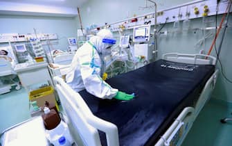 epa09525763 A Romanian nurse wearing full protective gear cleans, disinfects and exchanges the bed cover for another patient at the intensive care unit of the Covid-19 section of National Institute of Pneumology 'Marius Nasta', in Bucharest, Romania, 15 October 2021. Romania registered on 15 October 365 coronavirus related deaths, the highest number of daily deaths since the beginning of the pandemic. About 18,000 patients are hospitalized, of which 1,729 in intensive care units, in the entire country. Romanian health authorities are overwhelmed by the outbreak of the fourth wave, as the number of infected people with SARS-CoV-2 are rising from one day to another.  EPA/ROBERT GHEMENT