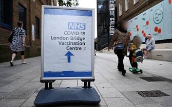 epa09457129 People walk past a Covid vaccination sign outside a hospital in central London, Britain, 09 September 2021. The UK government is expected to announce a decision on Covid vaccination boosters and vaccinations for children aged twelve to fifteen years of age.  EPA/ANDY RAIN