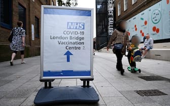 epa09457129 People walk past a Covid vaccination sign outside a hospital in central London, Britain, 09 September 2021. The UK government is expected to announce a decision on Covid vaccination boosters and vaccinations for children aged twelve to fifteen years of age.  EPA/ANDY RAIN