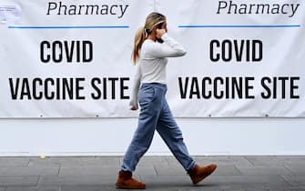 epa09465669 A woman walks past a Covid-19 vaccination centre in London, Britain, 13 September 2021. British Prime Minister Boris Johnson is set to outline his government's Covid winter plan on 14 September. The government has already announced that twelve to fifteen year olds should receive one dose of the Pfizer vaccine.  EPA/ANDY RAIN